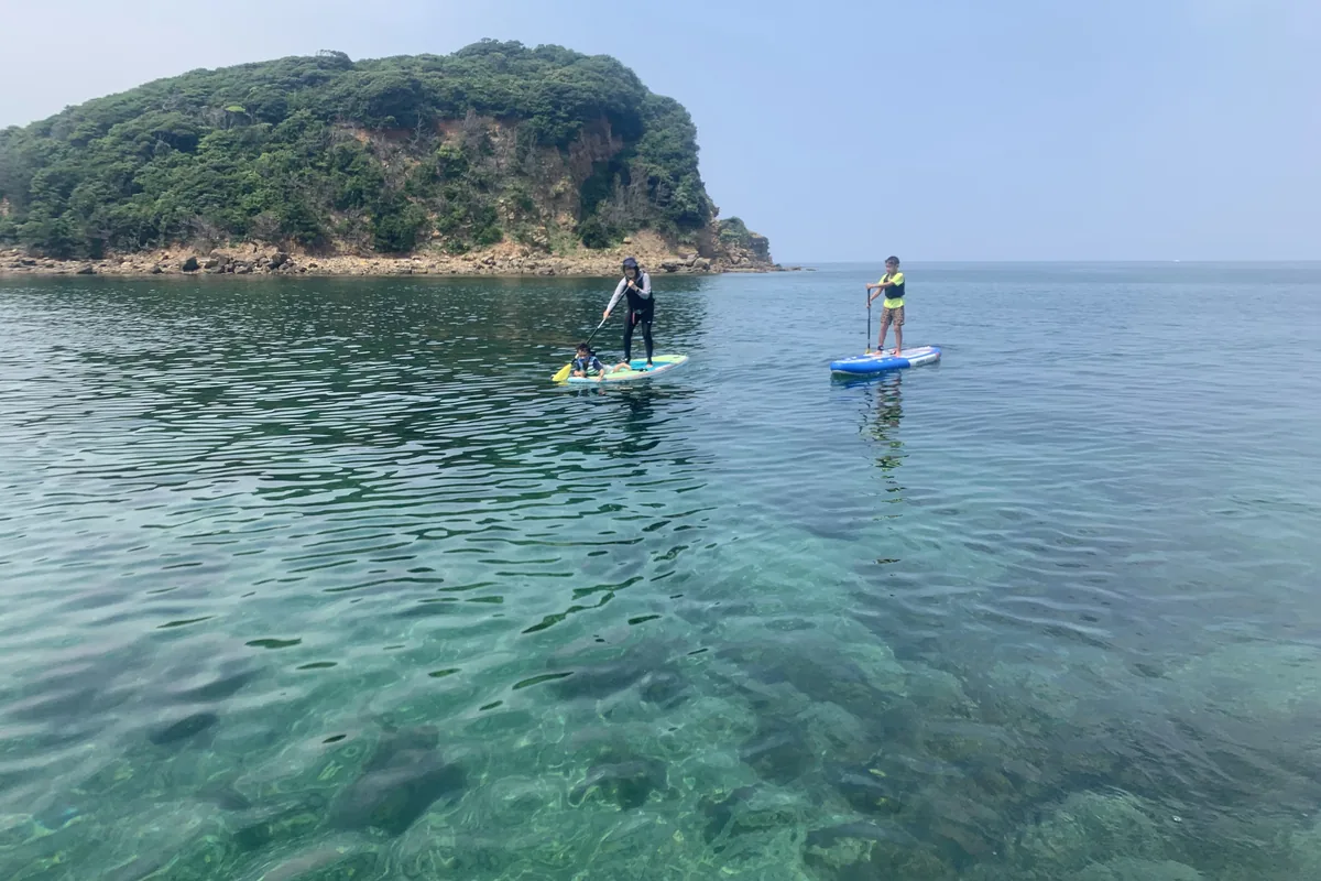 透明度の高い海をSUPで進む2人