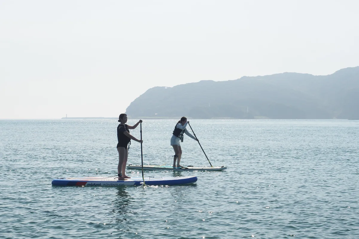 遠くの島影に向かってSUPで進む2人