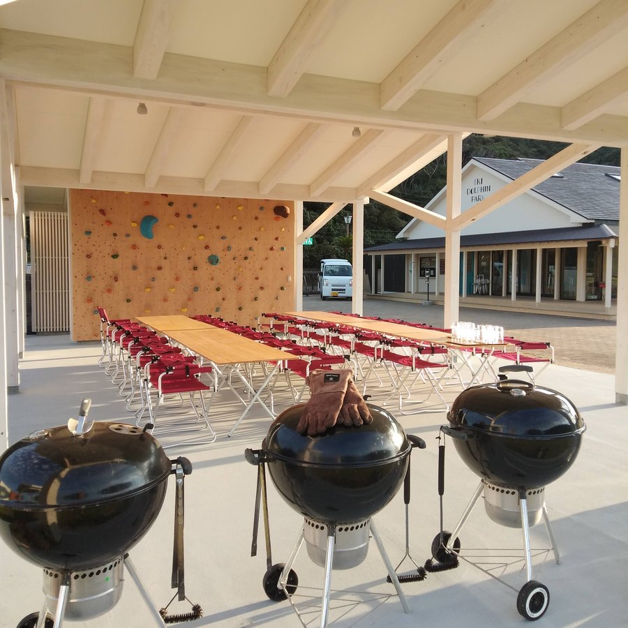 屋根のあるスペースに並んだBBQコンロと長机